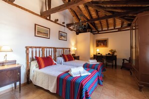 A hotel room with two beds, a wooden ceiling, and a desk with a chair. - Casa del Labrador - Finca & Spa Vereda Real (Albacete)