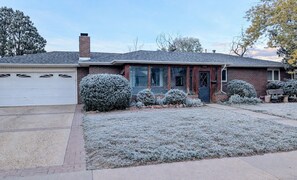 A residential house with a garage, a brick facade, a front door, and a small front yard with bushes. - Amazing central location across from CU Boulder (Boulder)