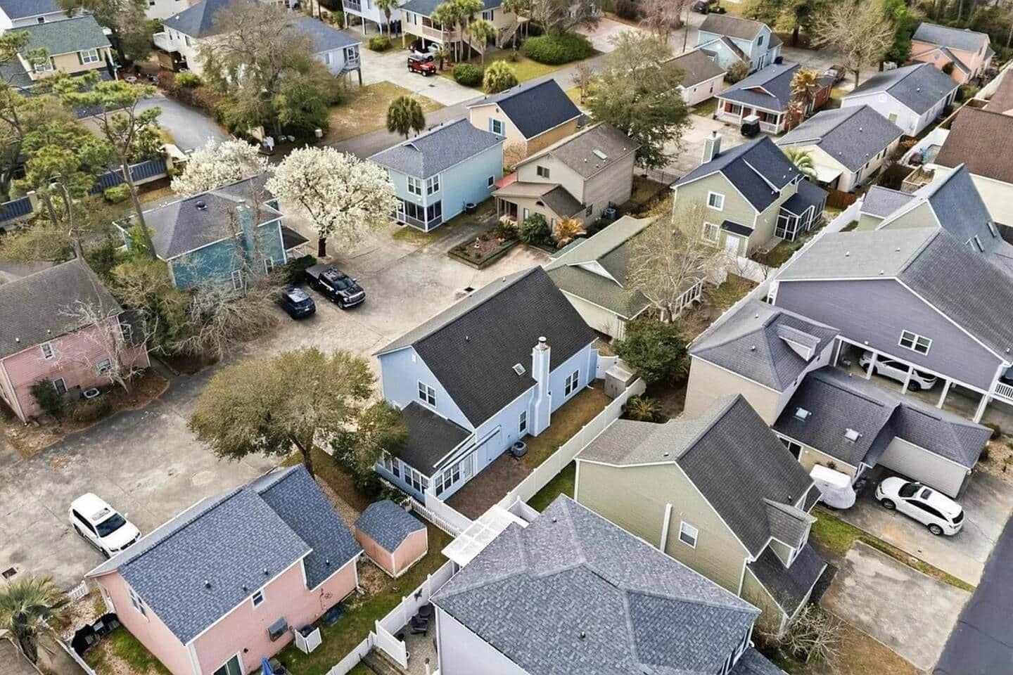 Un quartier résidentiel composé de plusieurs maisons, dont certaines sont dotées de garages attenants et d’autres d’allées visibles.