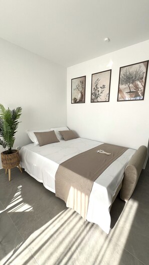 A modern bedroom with a bed, pillows, a bedside plant, and framed artwork on the wall. - Apartment 'Terrace  Makarska' with Sea View, Wi-Fi and Air Conditioning (Makarska)