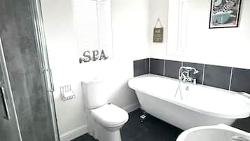 Ein Badezimmer mit einer Duschkabine, einer weißen Toilette, einer weißen Badewanne und einem Waschbecken.