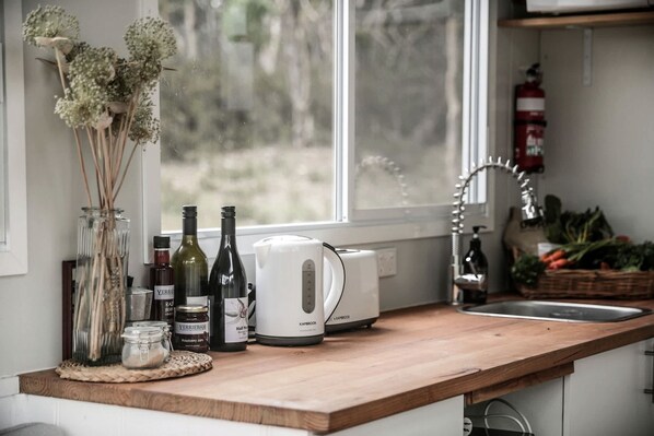 A kitchen counter with a coffee maker, bottles, and jars.