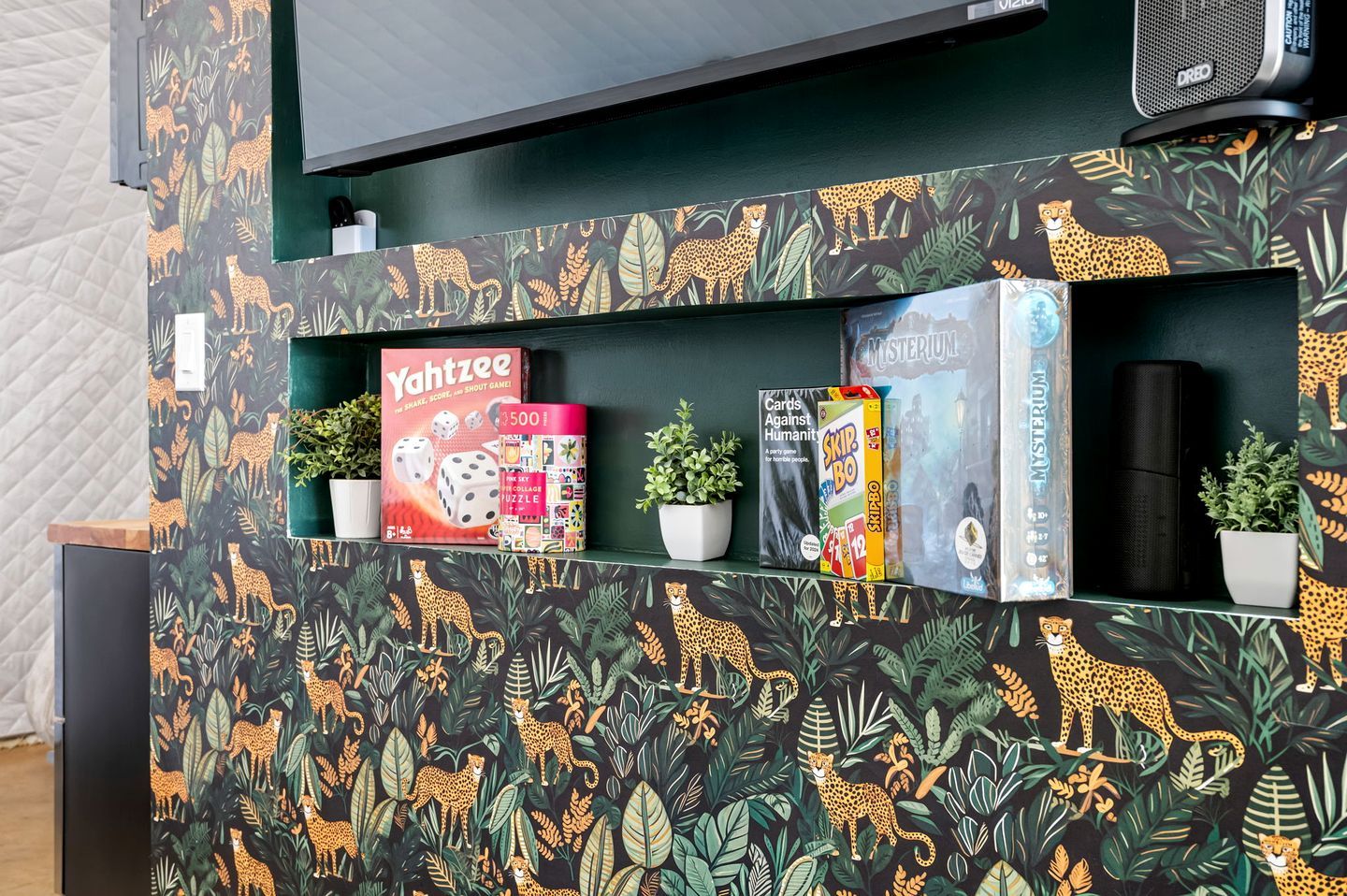A shelf with various board games and a speaker.