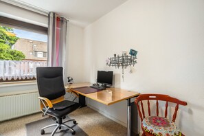 A small office space with a desk, computer, chair, and a decorative wall piece. - Holiday Apartment 'Eselei' with Shared Garden and Wi-Fi (Belm)