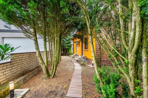 A pathway leading to a yellow building surrounded by trees. - Holiday Apartment 'Eselei' with Shared Garden and Wi-Fi (Belm)