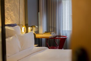 A hotel room with a bed, a desk with a lamp, a chair, and a window with curtains. - LETOH Ribeira (Porto)