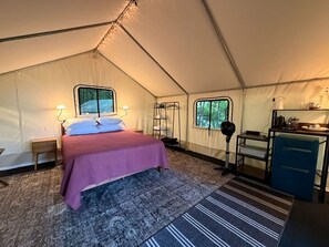 Una tenda con un letto, una scrivania e una finestra.