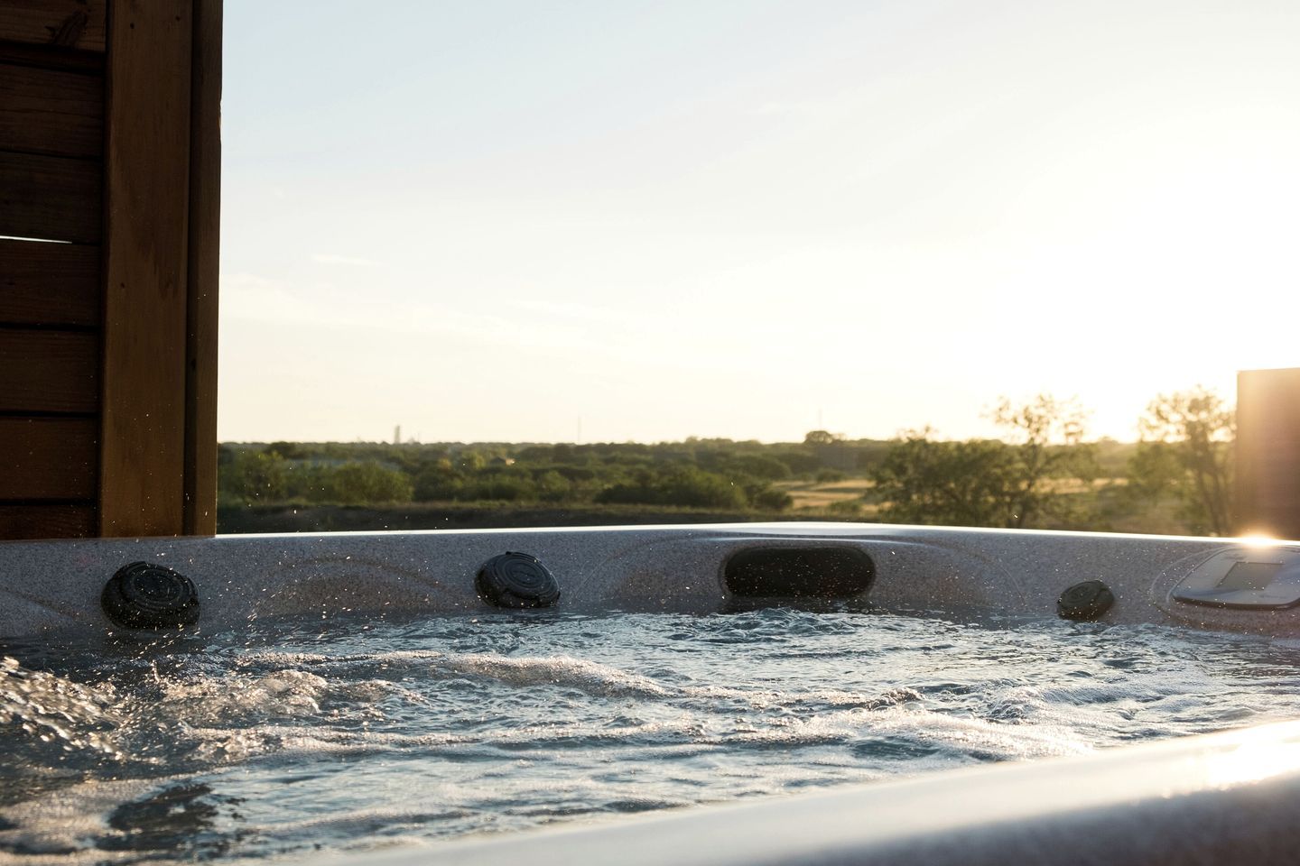 Ein Whirlpool mit Blick auf eine Landschaft bei Sonnenuntergang.