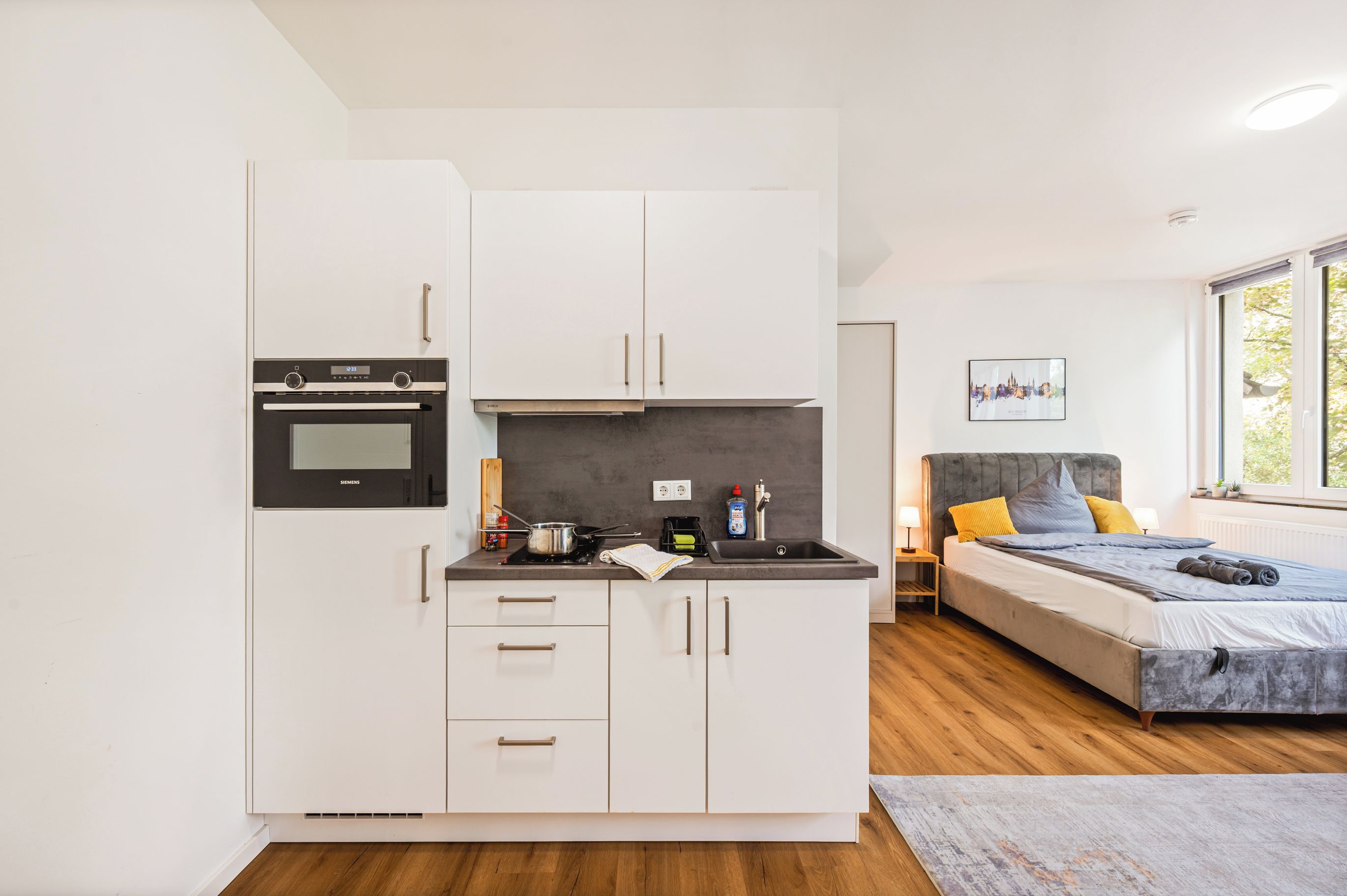 A compact kitchen with a built-in oven, a stovetop, and a sink.