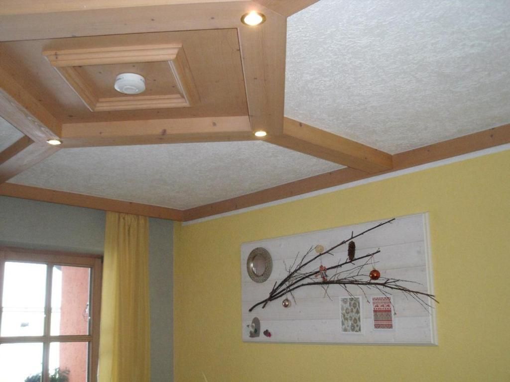A room with a wooden ceiling and a wall-mounted decoration.