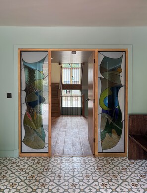 A room with a patterned floor, a wooden door with frosted glass panels, and a view through to a staircase. - Beautiful new build with outstanding views, huge lounge, high quality cinema. (Kirkby Stephen)