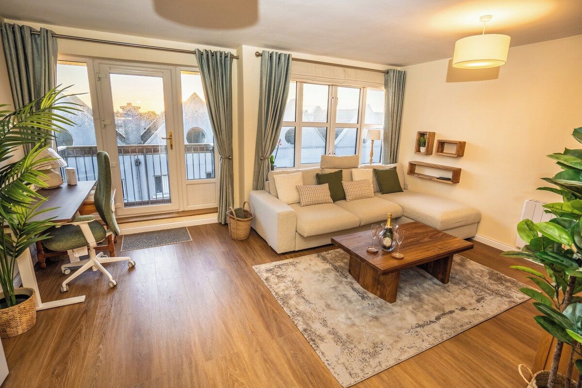 A living room with a sofa, coffee table, and a dining area with chairs and a table.