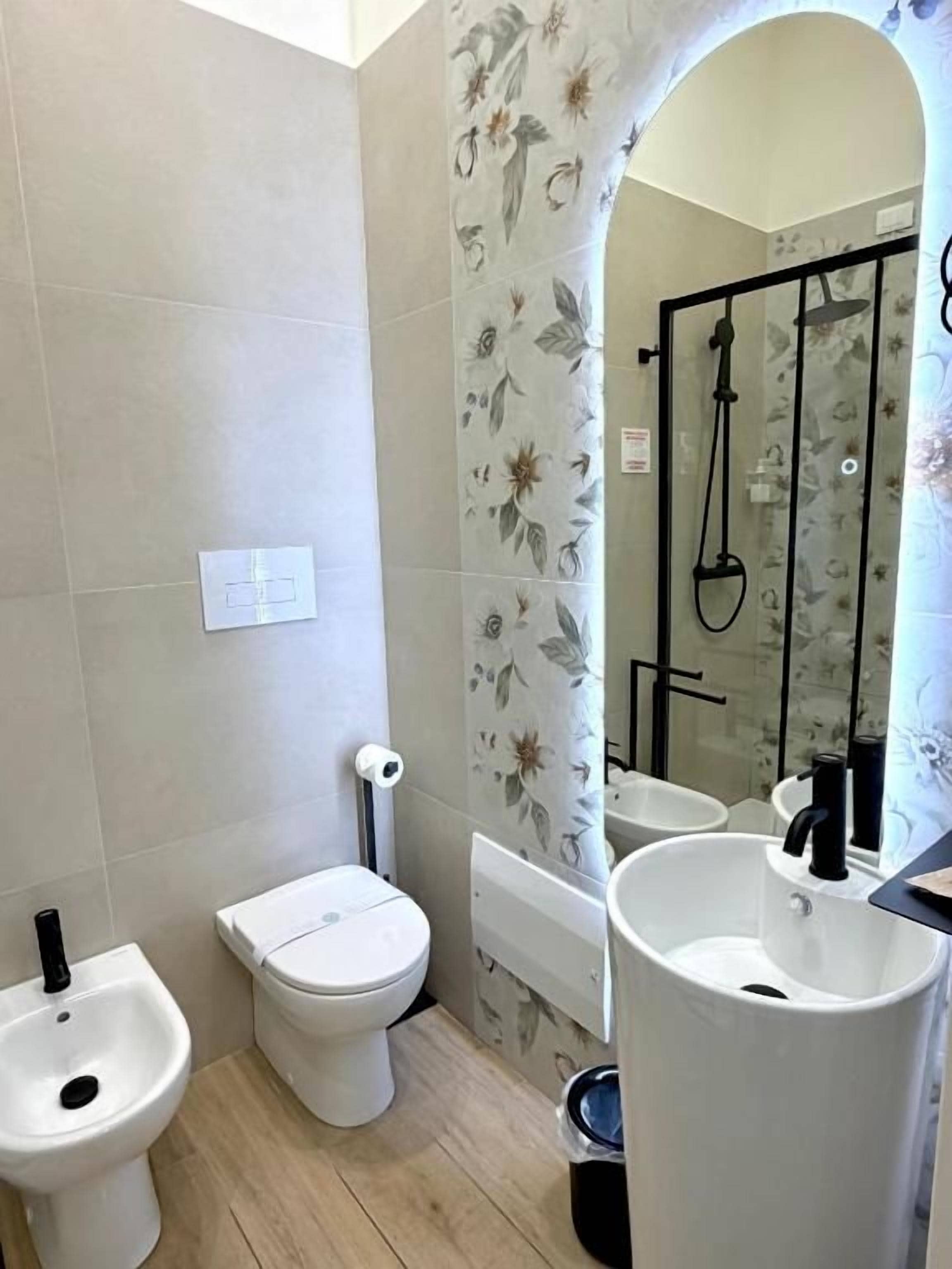 Une salle de bain comprenant des toilettes, un bidet, un lavabo et une douche.