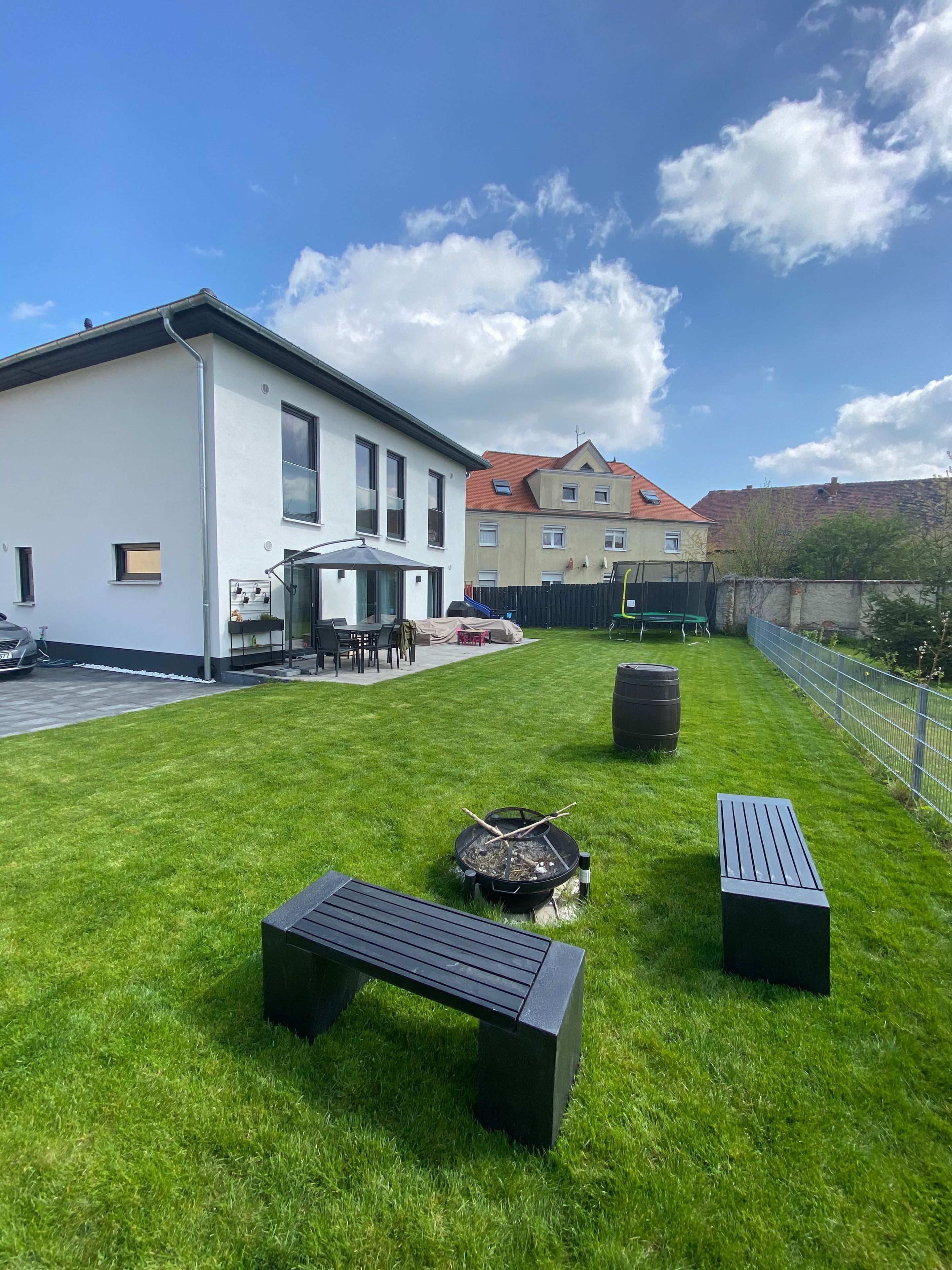 Ein moderner Außenbereich mit Feuerstelle, Bänken und einem Patio-Tisch.