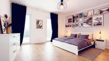 A bedroom with a bed, bedside tables, a dresser, and a large window.