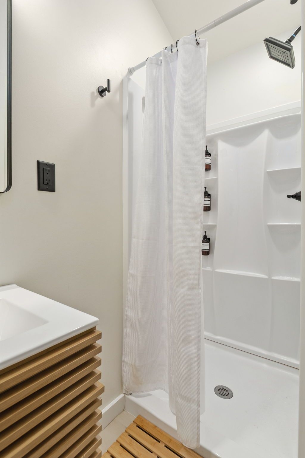 A bathroom with a shower, a sink, and a toilet.