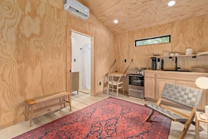 A compact kitchen with a built-in oven, a coffee maker, and a sink.
