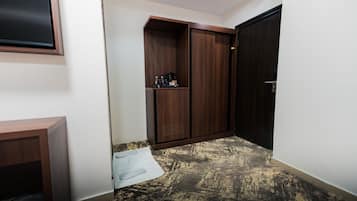 A hallway with a wardrobe, a small table, and a door.