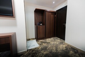 Un pasillo con un armario, una mesita y una puerta.
