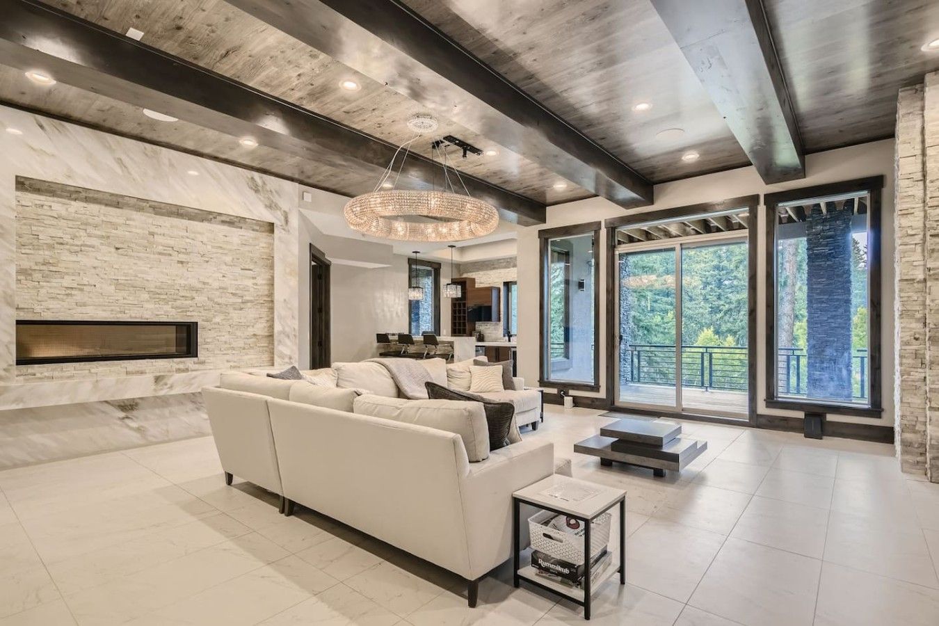 A modern living room with a fireplace, a large sofa, and a dining area.