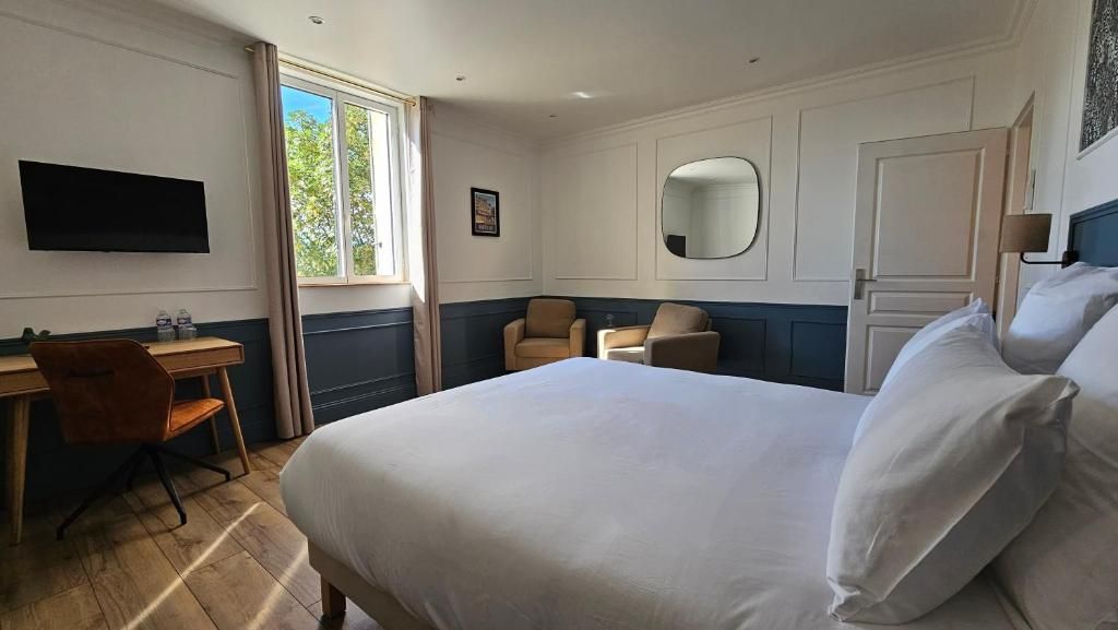 A hotel room with a bed, a desk, a chair, a TV, a window, and a door.