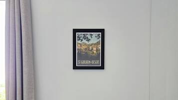 Een lijst met een foto van de St. Gulik Woestijn, een witte muur, een grijze bank en een raam met grijze gordijnen.