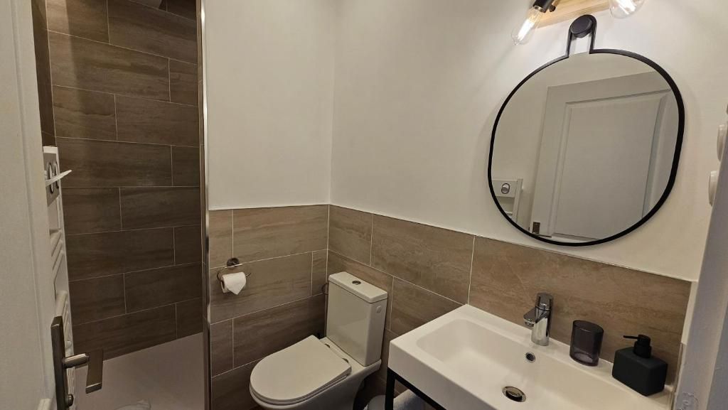 Un baño con inodoro, lavabo y espejo.