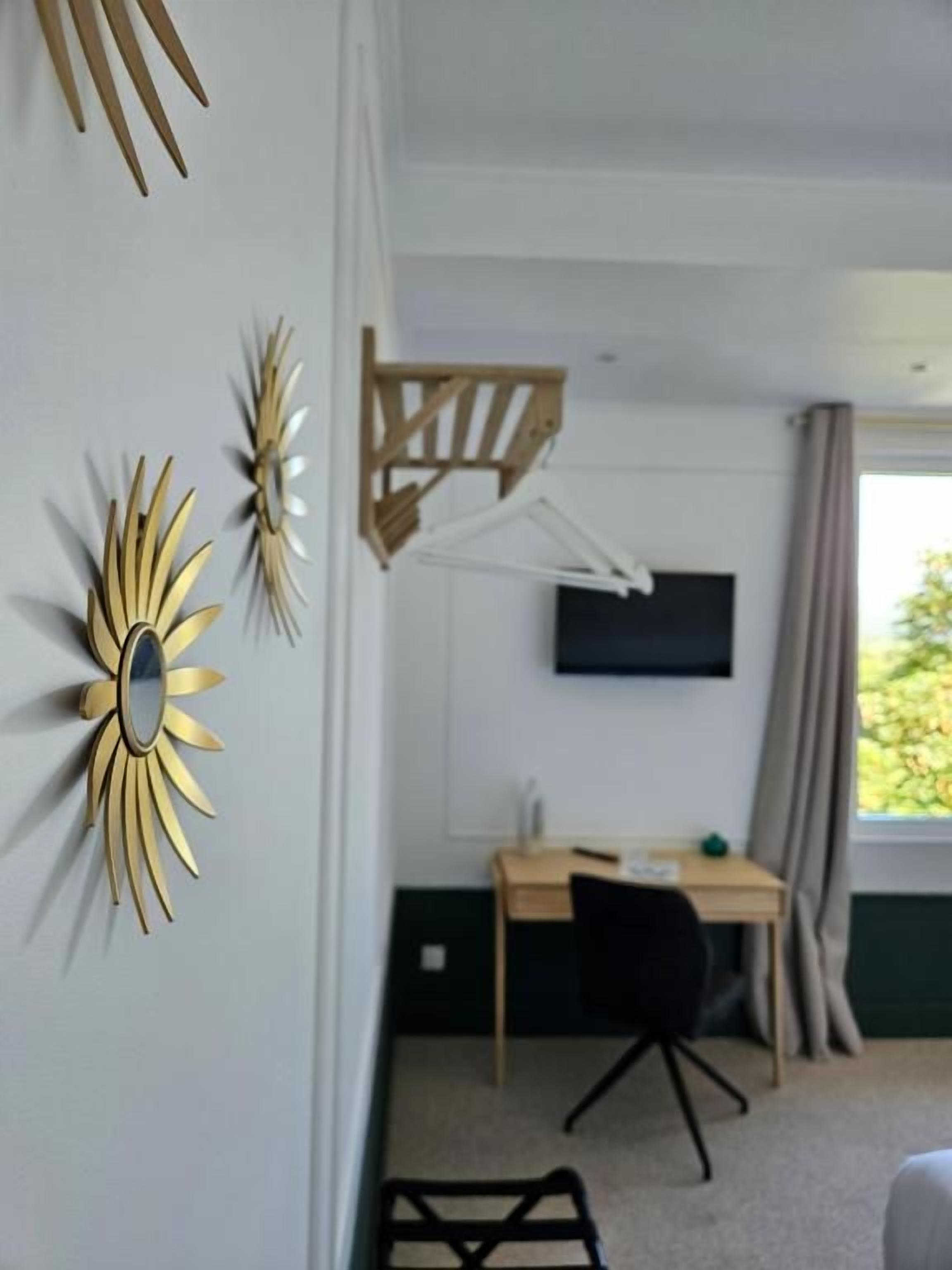 Een kamer met een bureau, stoel en een aan de muur bevestigde televisie.
