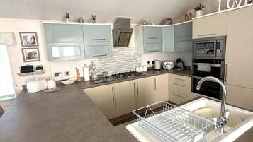 Una cocina moderna con una isla central, electrodomésticos de acero inoxidable y un salpicadero blanco.