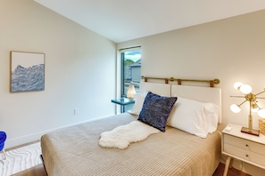 A modern bedroom with a bed, a bedside lamp, and a view of the outdoors. - Sip, Dine & Explore: Central Denver Escape! (Denver)