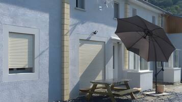 Un bâtiment doté de nombreuses fenêtres et une table avec un parasol.