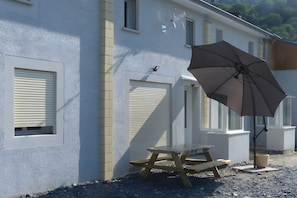 Een gebouw met meerdere ramen en een tafel met een parasol.