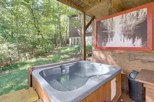 A hot tub in a wooden cabin with a forest view.