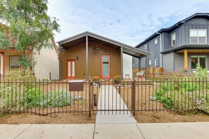 A residential building with a wooden facade, a red door, and a small garden area with a metal fence. - Walk to Rino & Coors Field! Modern Denver Home (Denver)