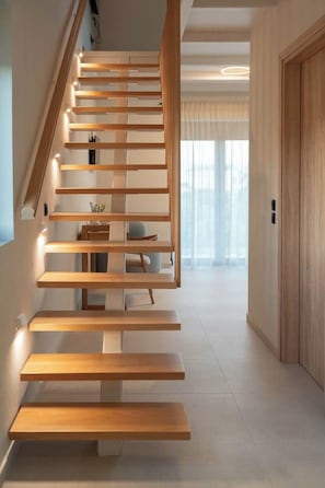 A modern staircase with wooden steps and built-in lighting. - Liokrina Suite 06 - Livadakia Poolside Getaway! (Livadakia)