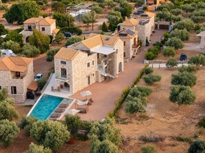 A residential area with stone buildings, a swimming pool, and a paved driveway. - Liokrina Suite 03 - Livadakia Poolside Getaway! (Livadakia)