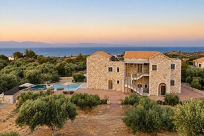 A stone villa with a pool, surrounded by olive trees and a view of the sea. - Liokrina Suite 05 - Livadakia Poolside Getaway! (Livadakia)