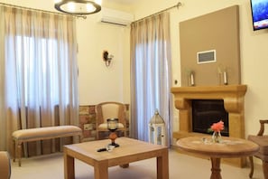 Una habitación con chimenea, una mesa, un banco y una silla.