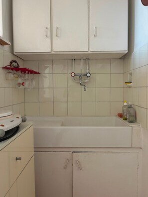 Una cucina con mobili bianchi, un lavello e un rubinetto.