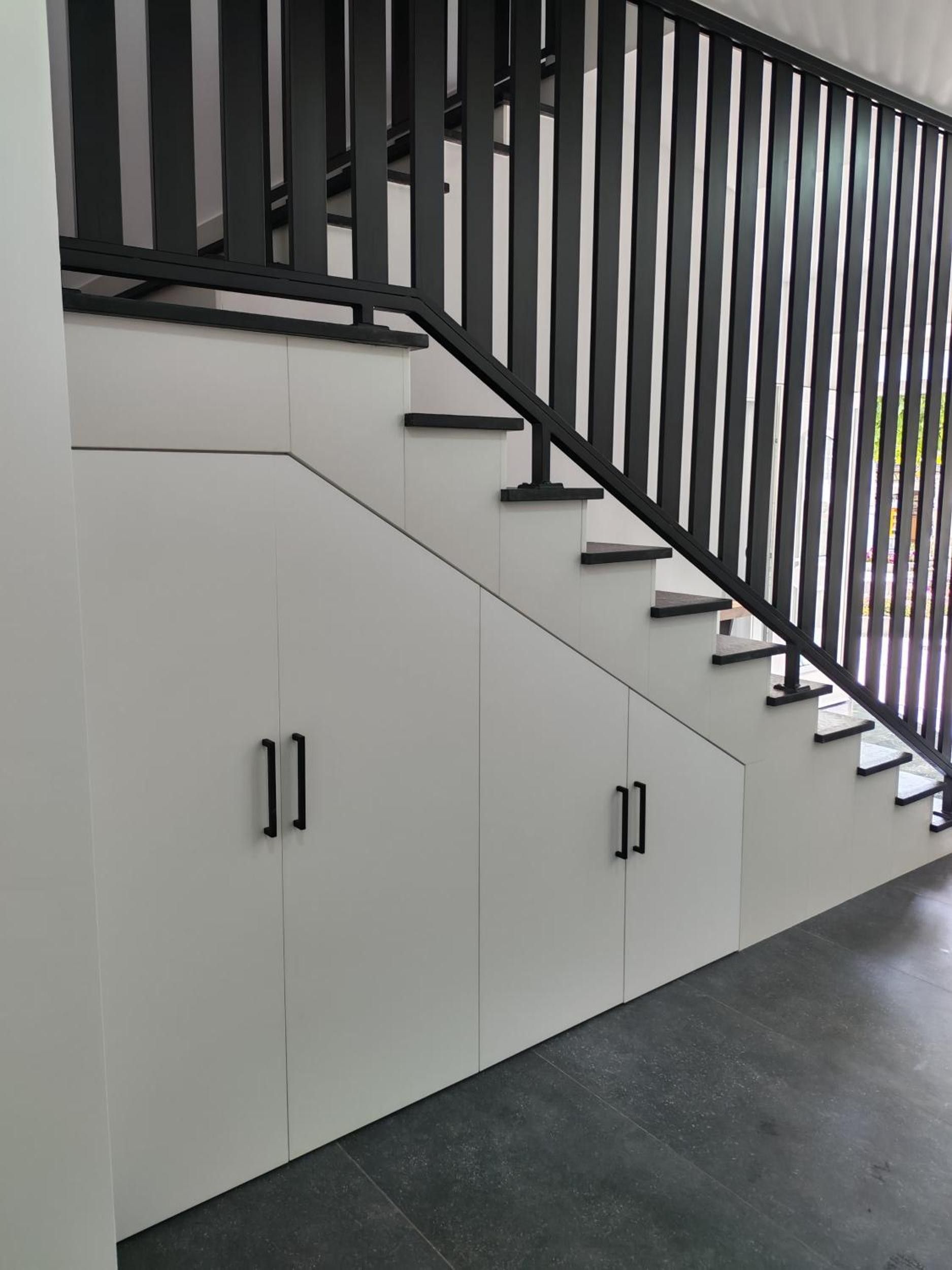A modern staircase with black railings and white walls.