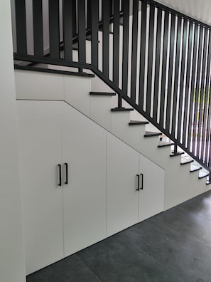Una escalera moderna con barandillas negras y paredes blancas.