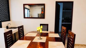 A dining table with six chairs, a candelabra with candles, and a mirror on the wall.