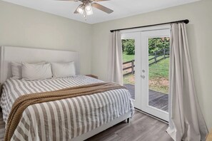 A bedroom with a bed, a ceiling fan, and a sliding glass door leading to an outdoor area. - Charming Mount Jackson Getaway (Mount Jackson)