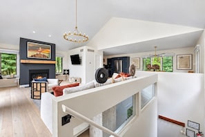 Un salon moderne avec une cheminée, un canapé et un coin repas.