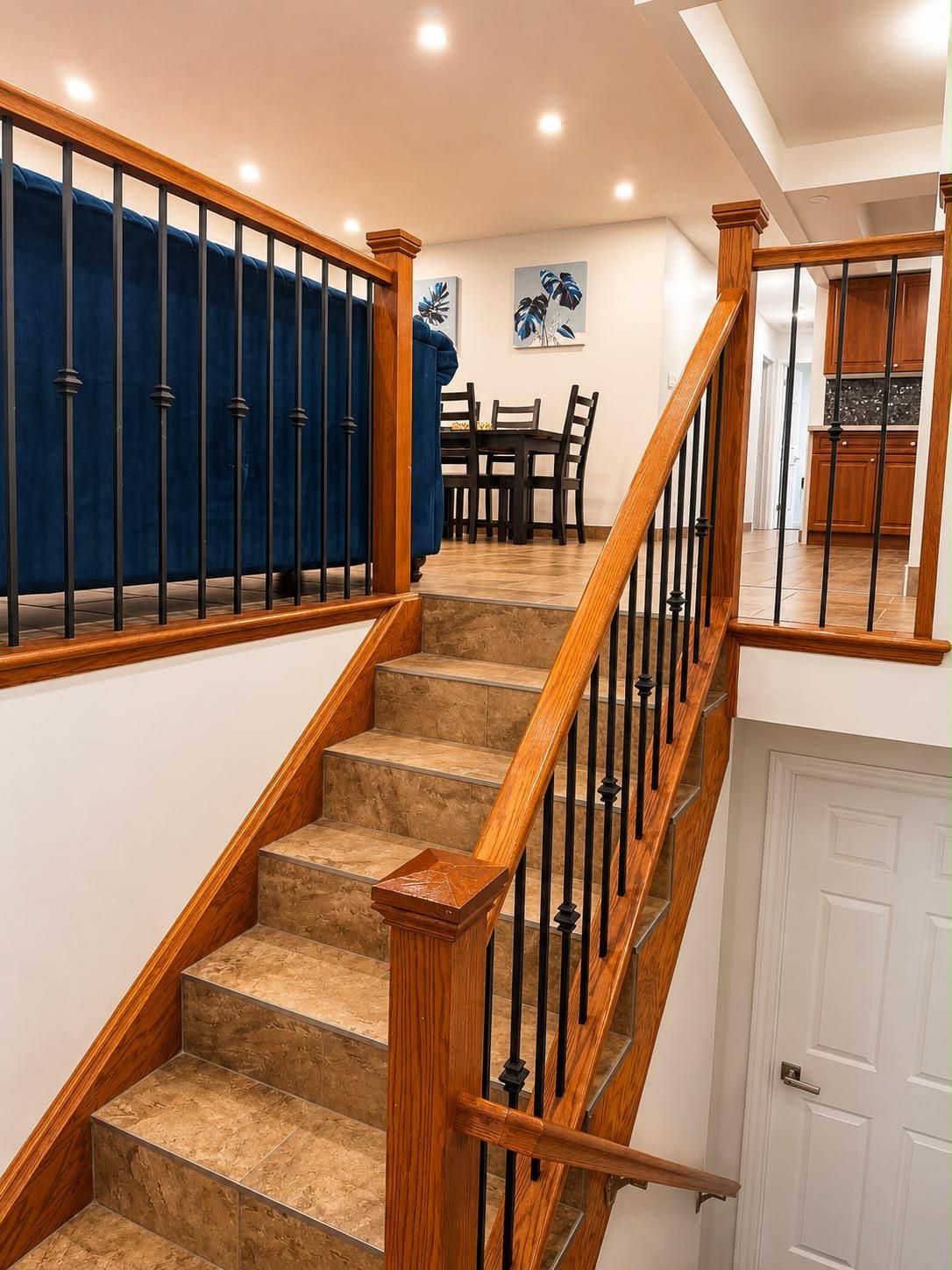 A staircase with wooden railings and beige carpeted steps leading to a white door.