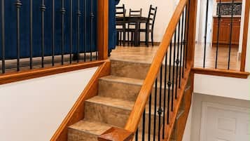 A staircase with wooden railings and beige carpeted steps leading to a white door.