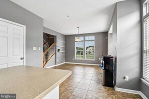 A kitchen with a granite countertop, a water dispenser, and a view of the outdoors through a window. - jjjjjjjjjjj (Hanover)