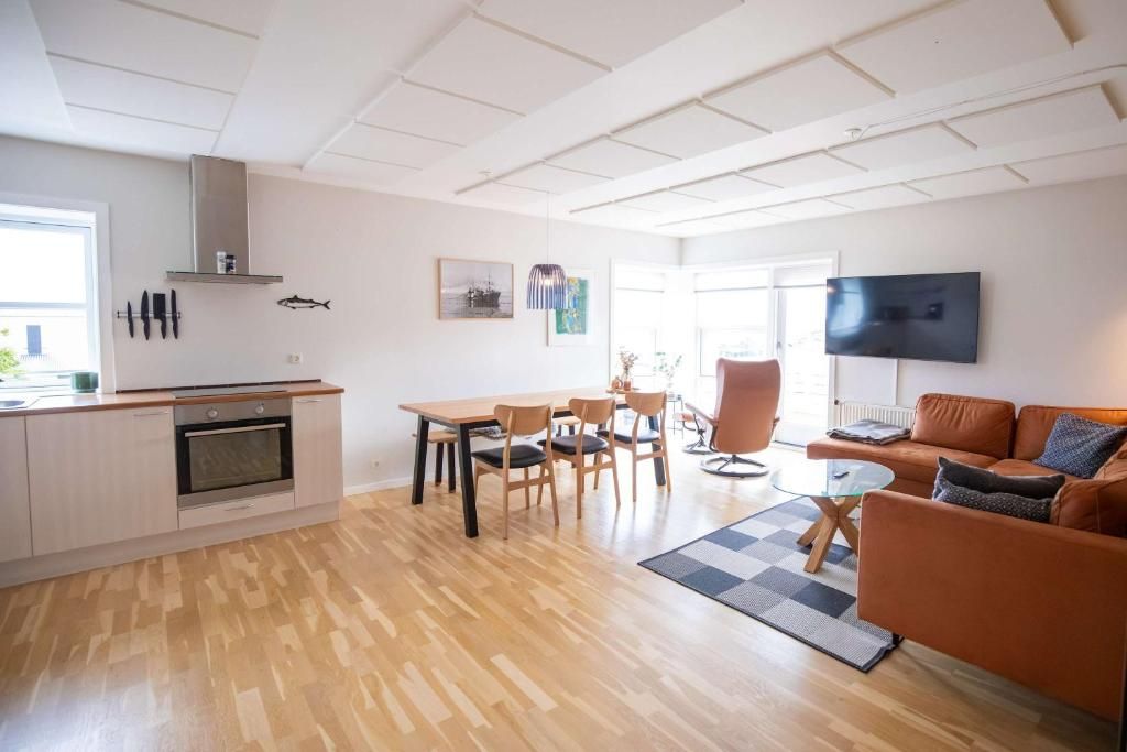 A modern living space with a kitchen, dining area, and seating area.