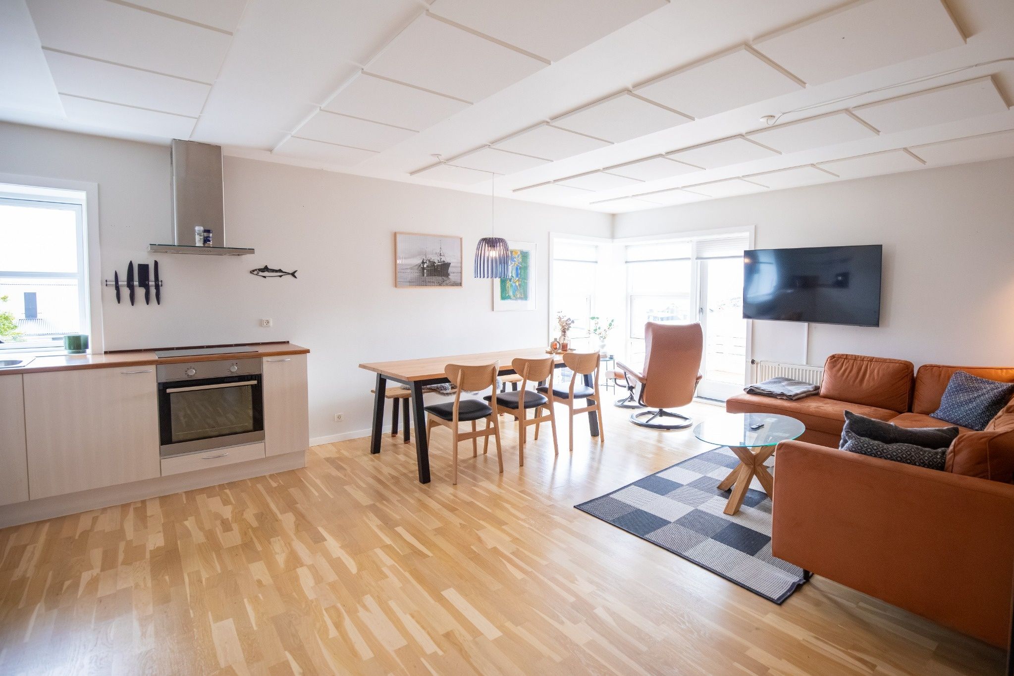 A modern living space with a kitchen, dining area, and seating area.