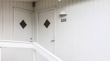 Un edificio blanco con una escalera que lleva a una puerta con la inscripción '14V'.